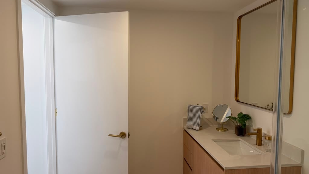 Bathroom vanity with brass-framed mirror