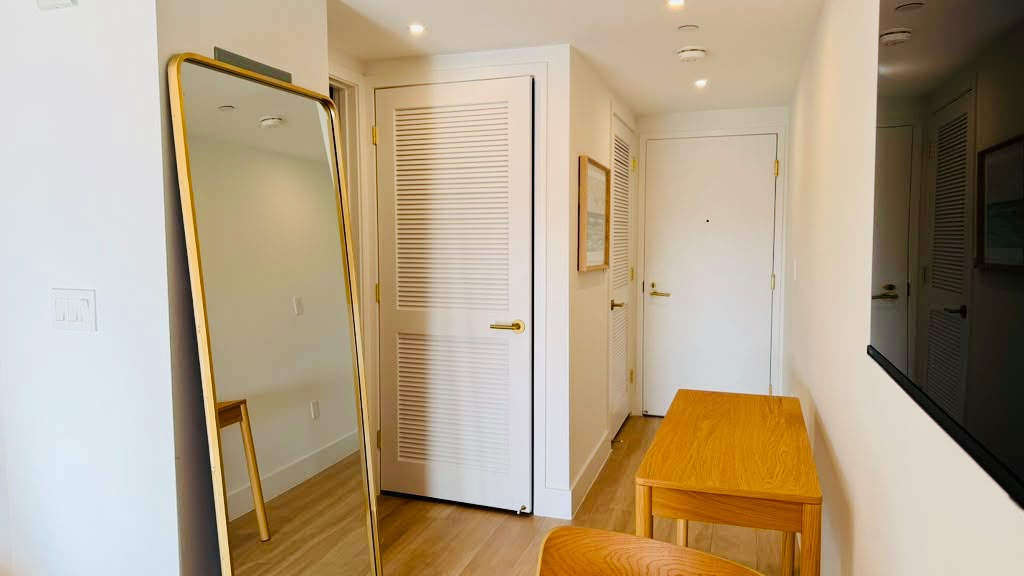 Entry hallway with full-length mirror and bench