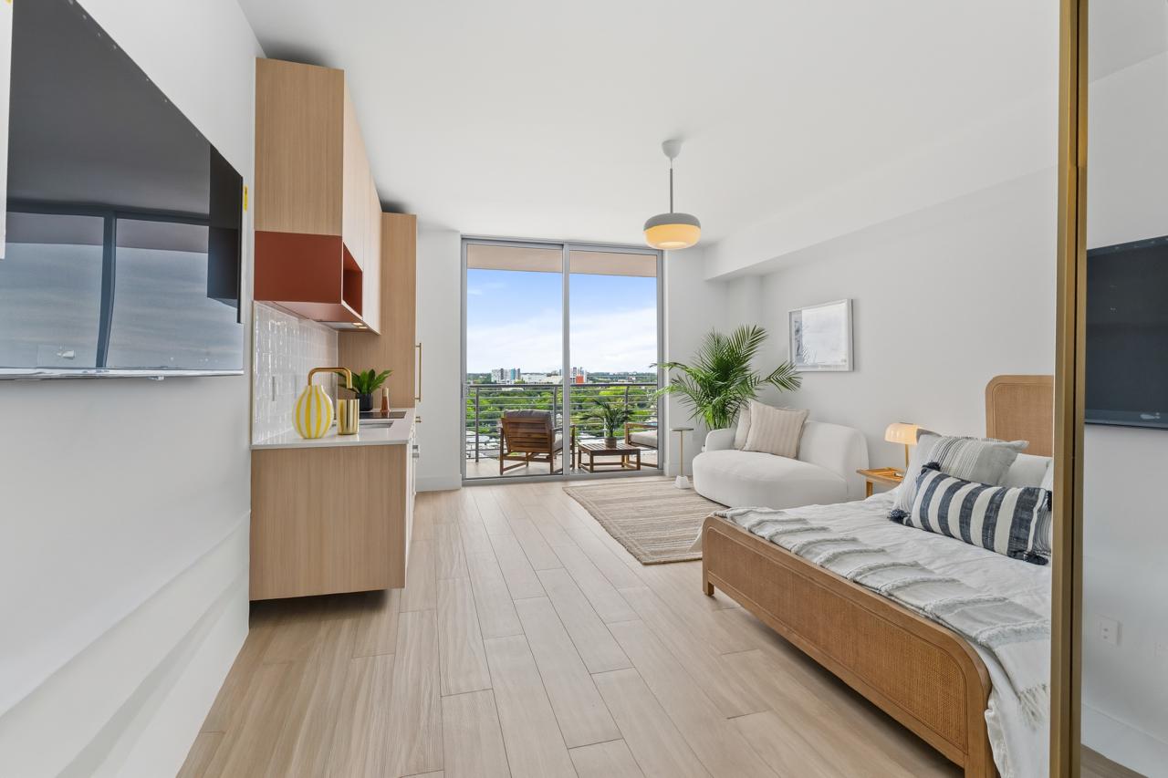 Fully furnished studio with bed, sofa, and kitchenette